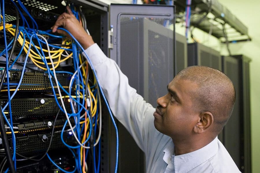 A man working on wires in an industrial setting.