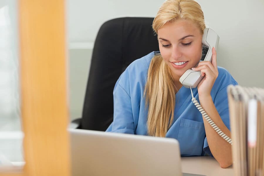 A woman sitting at her desk on the phone.